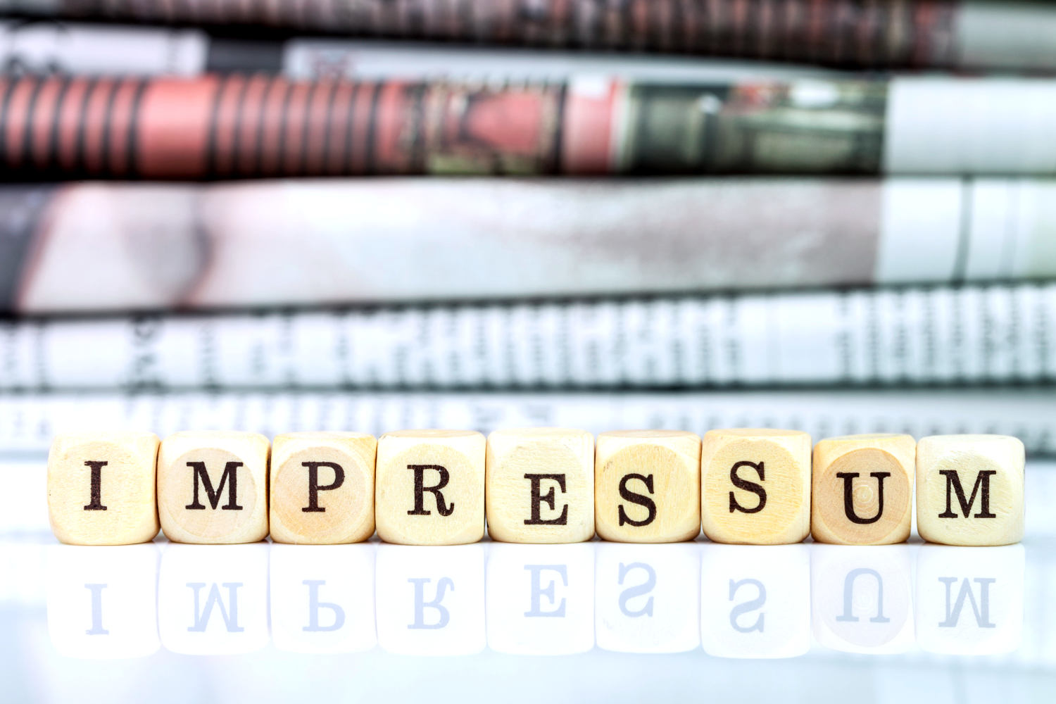 Impressumg written on dice with letters; Picture by querbeet von Getty Images; Canva